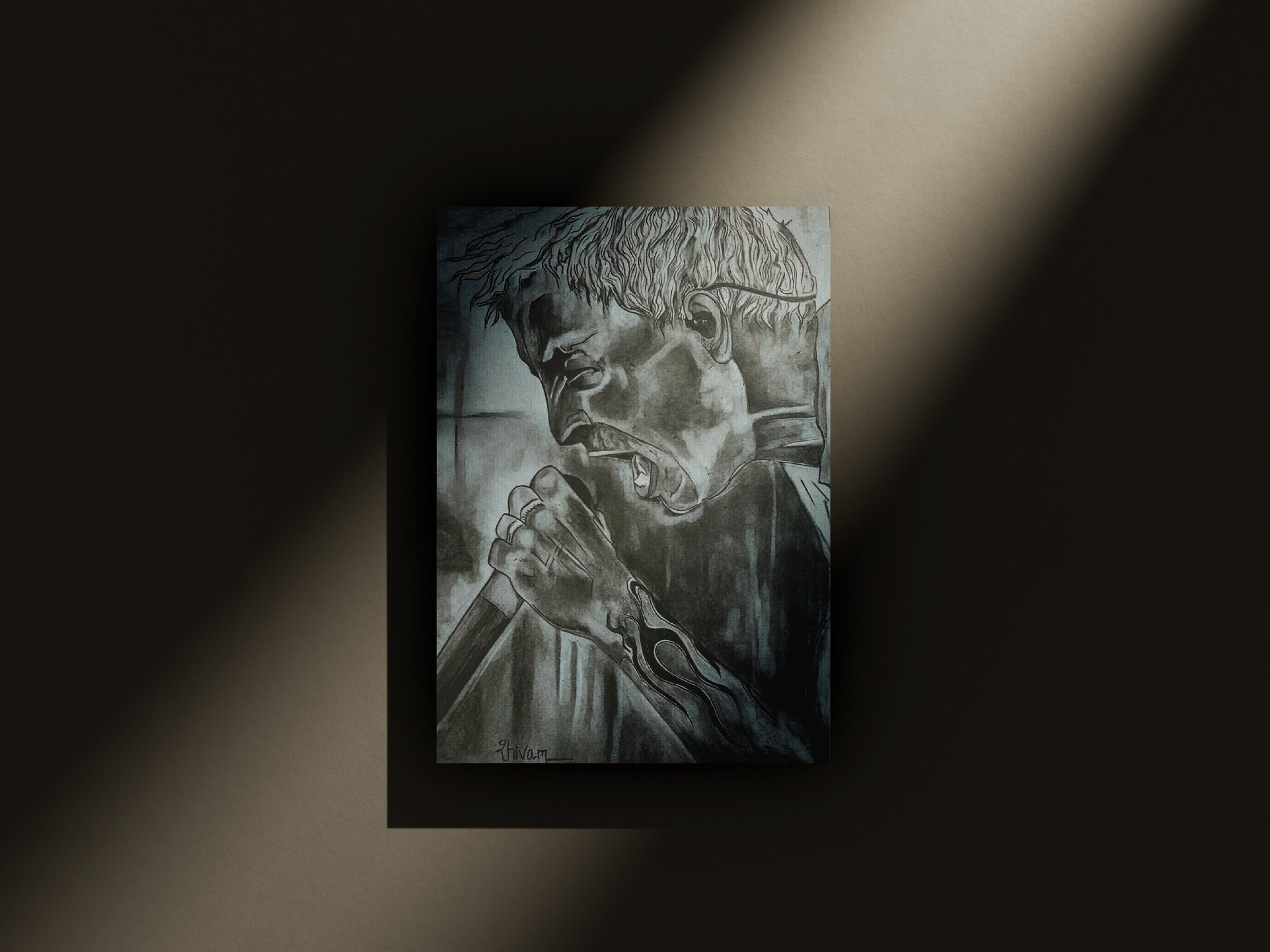 Charcoal drawing of an expressive face, displayed on a dark wall in angled light